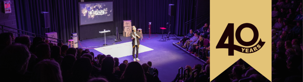 performer on stage with a beige banner with 40 years