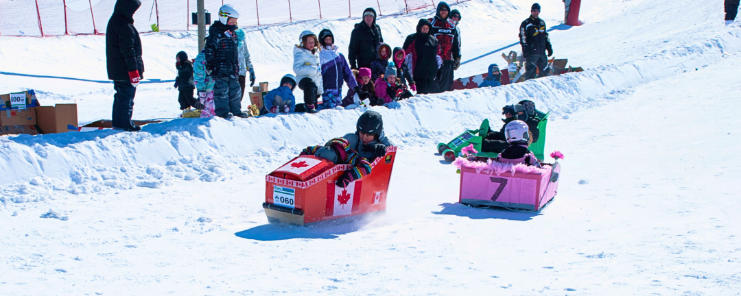 kids coming down the hill at the ROC in cardboard toboggans